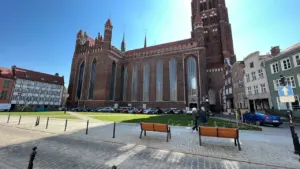Historyczny budynek bazyliki w Gdańsku w słoneczny dzień, widok z zewnątrz.
